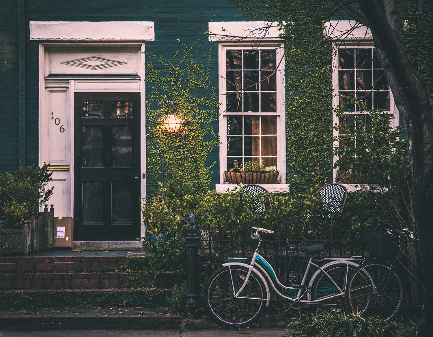 Photo of green brick home with bicycle